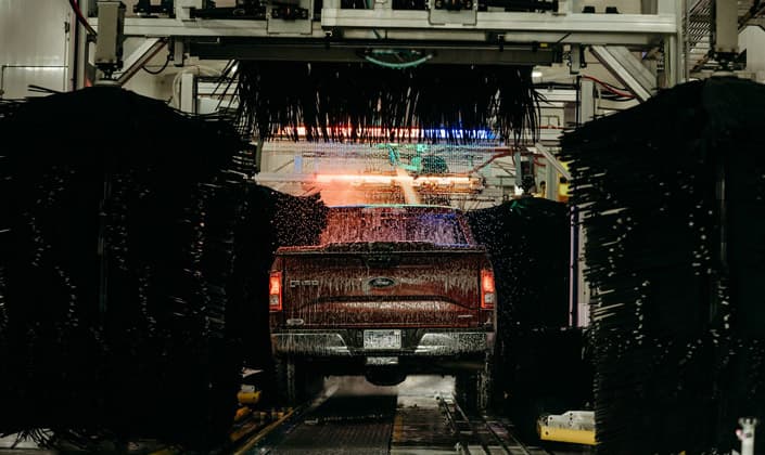 A pickup truck moving through the Jerry's Car Wash tunnel